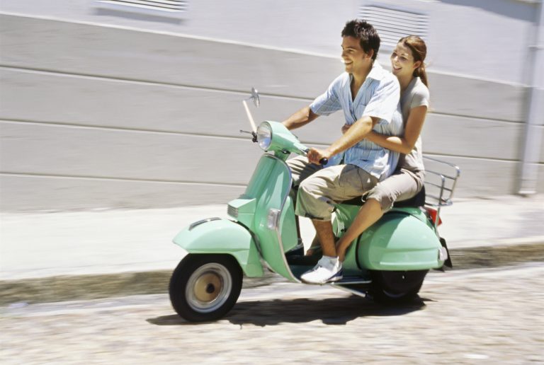 pareja viajando en motoneta