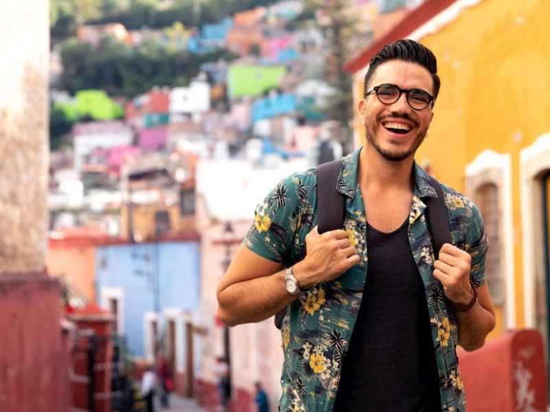 se observa un hombre feliz cargando su mochila haciendo turismo entre las calles de guatemala