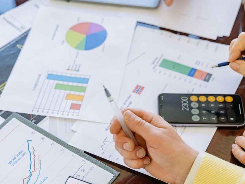 Manos analizando gráficos y resultados como parte de la evaluación de productividad y desempeño en el trabajo.