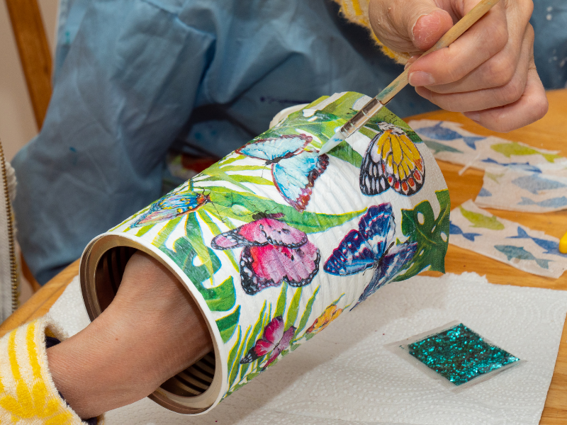 jarrón pintado de blanco con mariposas de colores 